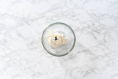 Foto de Flat lay. Mixing food coloring into the buttercream frosting to decorate American flag mini cupcakes. - Imagen libre de derechos