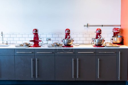 Photo for Denver, Colorado, USA-October 30, 2021 - Row of red standing kitchen mixers at the cooking class. - Royalty Free Image