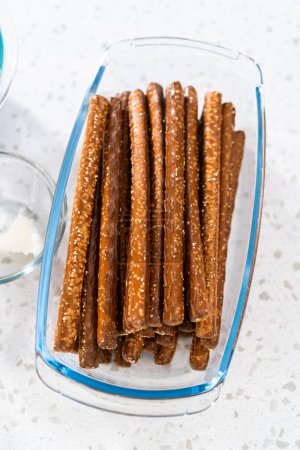 Foto de Ingredientes medidos en cuencos de vidrio para hacer barras de pretzel cubiertas de chocolate Halloween. - Imagen libre de derechos