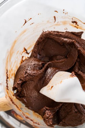 Téléchargez les photos : Fondre les pépites de chocolat blanc et d'autres ingrédients dans un bol de mélange en verre sur de l'eau bouillante pour préparer le caramel à la canne à sucre. - en image libre de droit