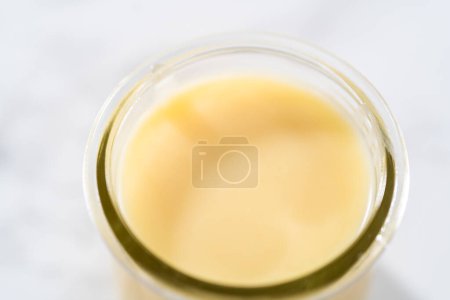 Foto de Ganache de chocolate blanco en un frasco de albañil de vidrio pequeño. - Imagen libre de derechos
