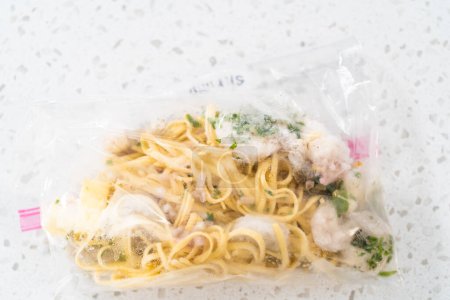 Téléchargez les photos : Préparation des repas. Paquets langoustines aux crevettes avec pâtes dans un plastique arrière pour stocker dans un congélateur. - en image libre de droit