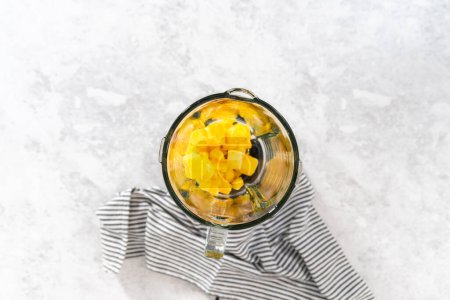 Photo for Flat lay. Mixing ingredients in kitchen blender to prepare mango boba smoothie. - Royalty Free Image
