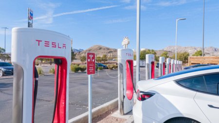Foto de Primm, Nevada, USA-December 3, 2022-Durante el día, un vehículo Tesla se ve cargando en una estación de sobrecarga Tesla, utilizando la infraestructura de carga de alta velocidad para conveniente y eficiente - Imagen libre de derechos