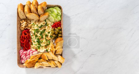 Photo for Flat lay. A large vegetarian party butter board with fresh and pickled vegetables and sliced french baguette for a party. - Royalty Free Image