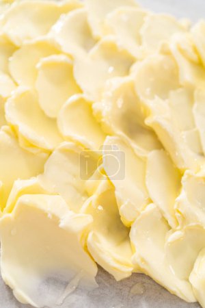 Téléchargez les photos : Étaler du beurre non salé à température ambiante pour préparer une planche de beurre végétarienne pour une fête. - en image libre de droit