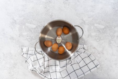 Photo for Flat lay. Boiling brown organic eggs in a cooking pot to prepare hard-boiled eggs. - Royalty Free Image