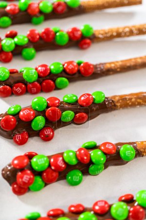 Photo for Denver, Colorado, USA-December 18, 2022-Dipping pretzel rods into melted chocolate and sprinkling candies to make chocolate-covered pretzel rods. - Royalty Free Image