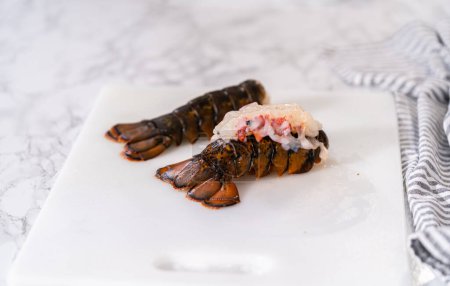 Téléchargez les photos : Préparation de queues de homard crues pour faire des queues de homard à l'ail. - en image libre de droit