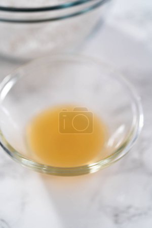 Téléchargez les photos : Glaçure au citron. Ingrédients mesurés dans des bols de mélange en verre pour préparer la glaçure au citron. - en image libre de droit