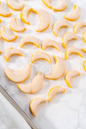 Téléchargez les photos : Biscuits au citron avec glaçage au citron. Tremper les biscuits au citron dans un glaçage au citron. - en image libre de droit
