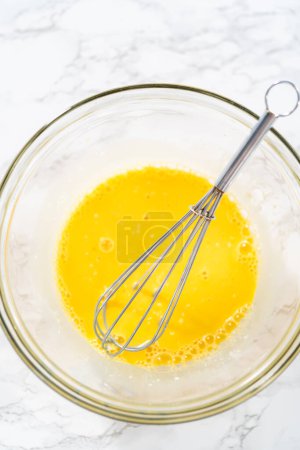 Téléchargez les photos : Biscuits au citron avec glaçage au citron. Mélanger les ingrédients humides dans un grand bol de mélange en verre pour cuire des biscuits au coin de citron. - en image libre de droit
