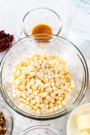 Photo for Measured ingredients in glass mixing bowls to make white chocolate cranberry pecan fudge. - Royalty Free Image