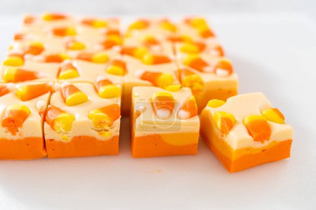 Foto de Piezas cuadradas de caramelo hecho en casa fudge de maíz en una tabla de cortar blanca. - Imagen libre de derechos