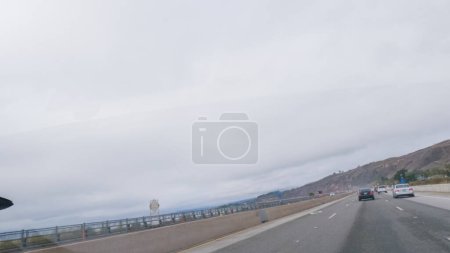 Téléchargez les photos : Los Angeles, Californie, États-Unis-4 décembre 2022-POV-Conduite sur la Highway 101 près de Rincon Beach, Californie, au milieu d'une journée d'hiver sombre et nuageuse. - en image libre de droit