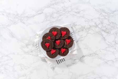 Photo for Flat lay. Decorating chocolate cookies with red chocolate hearts. - Royalty Free Image