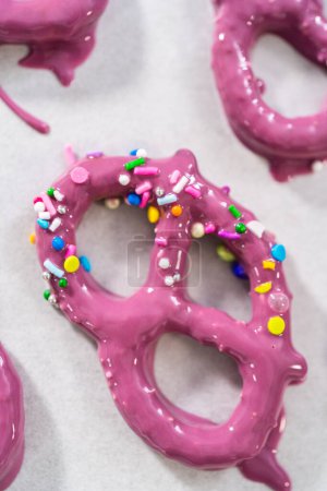 Photo for Dipping pretzels twists into melted chocolate to make mermaid pretzel twists. - Royalty Free Image