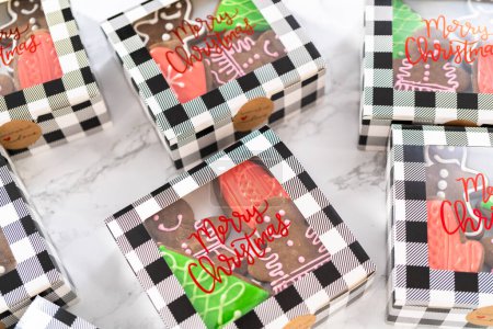 Photo for Packaging a homemade variety of fudge and gingerbread cookies for Christmas food gifts into paper boxes. - Royalty Free Image