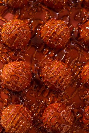 Photo for Drizzling caramelized sugar on top of silicone molds to make caramel cupcake toppers. - Royalty Free Image