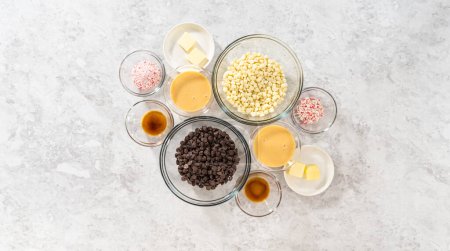 Photo for Flat lay. Measured ingredients in glass mixing bowls to make candy cane fudge. - Royalty Free Image