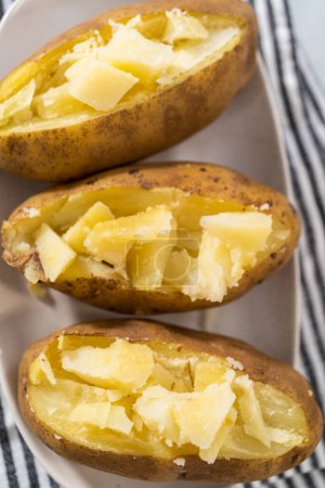 Photo for Pressure Cooker Baked Potatoes. Sliced cooked whole potatoes on a white plate to make baked potatoes. - Royalty Free Image