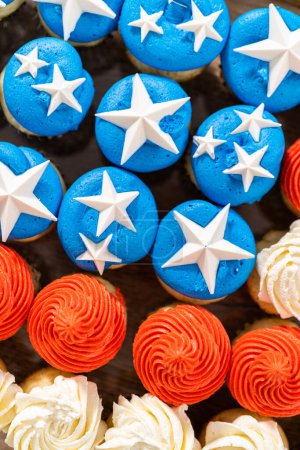 Téléchargez les photos : Arranging mini vanilla cupcakes in the shape of the American flag. - en image libre de droit