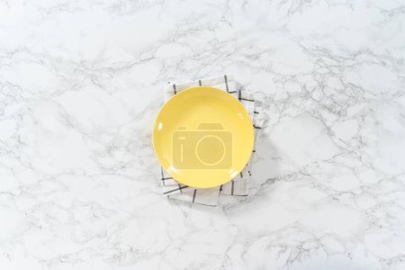 Téléchargez les photos : Plaque jaune vide sur une surface en marbre. - en image libre de droit