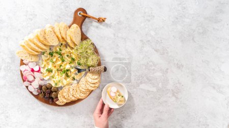 Photo for Flat lay. Butter board with vegetables and bread on a round wood cutting board. - Royalty Free Image