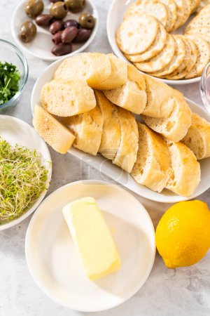 Téléchargez les photos : Ingrédients mesurés dans des bols à mélanger en verre pour faire du beurre avec des légumes et du pain. - en image libre de droit