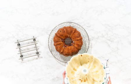 Photo for Flat lay. With precision, the bundt cake is carefully removed from the pan - placed onto a round cooling rack, preparing it for a flawless presentation and delightful indulgence. - Royalty Free Image