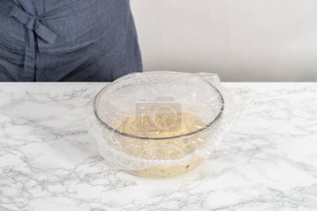Téléchargez les photos : Pâte à lever dans un bol à mélanger en verre pour faire cuire mini pain de Pâques kulich. - en image libre de droit