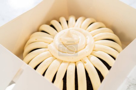 Téléchargez les photos : Avec soin, le gâteau Bundt au chocolat est emballé dans une boîte en papier blanc prêt à offrir pour apporter joie et indulgence à quelqu'un de spécial. - en image libre de droit