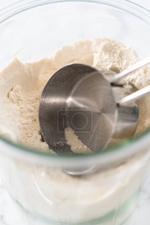 Téléchargez les photos : Tasse à mesurer dans un bocal en verre rempli de farine tout usage. - en image libre de droit