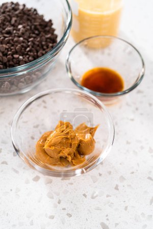 Téléchargez les photos : Ingrédients mesurés dans des bols de mélange en verre pour faire du caramel au beurre d'arachide au chocolat. - en image libre de droit