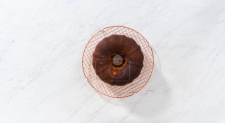 Photo for Flat lay. Cooling freshly baked gingerbread bundt cake with caramel filling on a kitchen counter. - Royalty Free Image