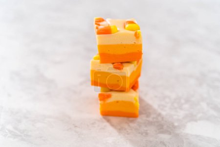 Photo for Homemade candy corn fudge square pieces stacked on a kitchen counter. - Royalty Free Image