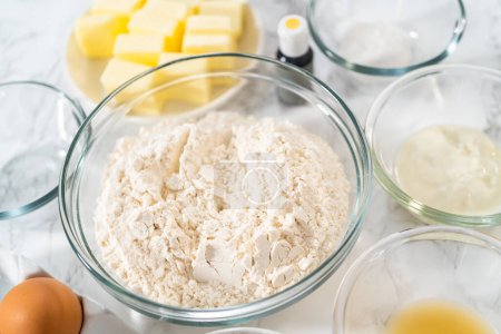 Photo for Lemon wedge cookies with lemon glaze. Measured ingredients in glass mixing bowls to prepare lemon wedge cookies. - Royalty Free Image