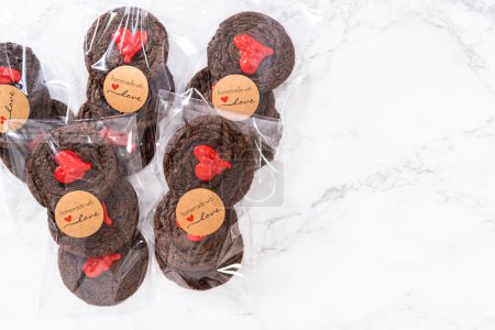 Téléchargez les photos : Biscuits au chocolat avec des cœurs de chocolat pour la Saint-Valentin emballés dans des sacs-cadeaux en plastique. - en image libre de droit