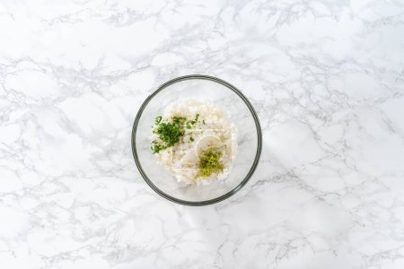 Photo for Flat lay. Cilantro Lime Rice. Mixing ingredients in a glass mixing bowl to prepare cilantro lime rice. - Royalty Free Image