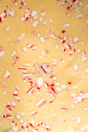 Téléchargez les photos : Enlever le caramel à la canne à sucre d'une poêle à gâteau au fromage carrée doublée de parchemin. - en image libre de droit