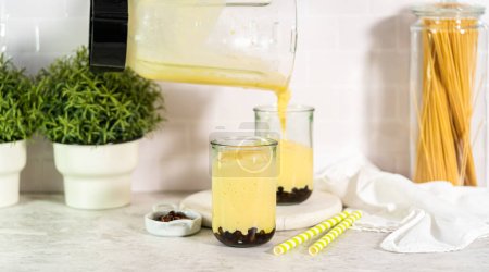 Photo for Pouring mango boba smoothie into the drinking glasses. - Royalty Free Image