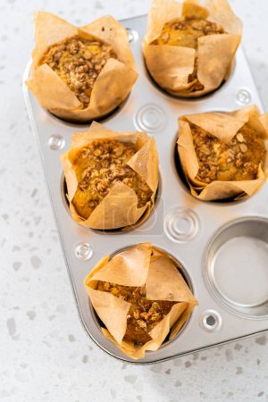 Téléchargez les photos : Muffins de flocons d'avoine de banane fraîchement cuits dans une petite casserole à muffins. - en image libre de droit
