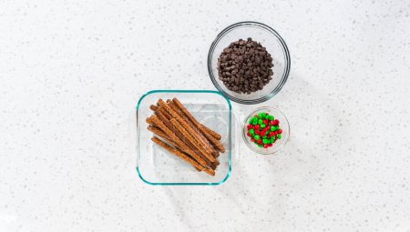 Photo for Denver, Colorado, USA-December 18, 2022-Flat lay. Measured ingredients in glass mixing bowls to make chocolate-covered pretzel rods. - Royalty Free Image