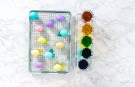 Foto de Acostado. Huevo de Pascua para colorear. Tinte huevos orgánicos blancos en diferentes colores para Pascua. - Imagen libre de derechos