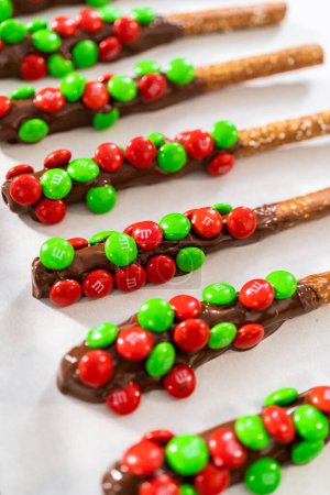 Téléchargez les photos : Denver, Colorado, États-Unis-18 décembre 2022-Trempage des tiges de bretzel dans du chocolat fondu et saupoudrage de bonbons pour faire des tiges de bretzel recouvertes de chocolat. - en image libre de droit