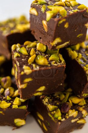 Téléchargez les photos : Homemade chocolate pistachio fudge square pieces on a white plate. - en image libre de droit