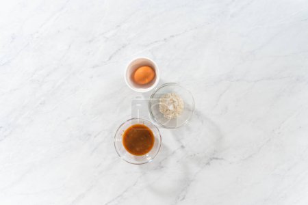 Téléchargez les photos : Pose plate. Ingrédients mesurés dans des bols à mélanger en verre pour préparer le remplissage au caramel. - en image libre de droit