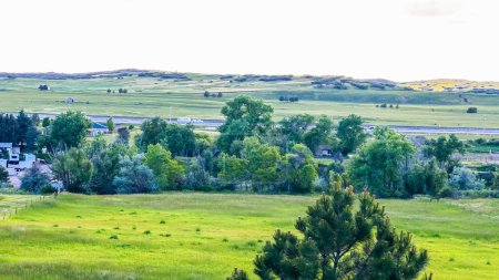 Photo for From the newly developed residential neighborhood in Colorado, a captivating view unfolds, showcasing vast farmland and a majestic mountain range in the distance, creating a picturesque and serene - Royalty Free Image
