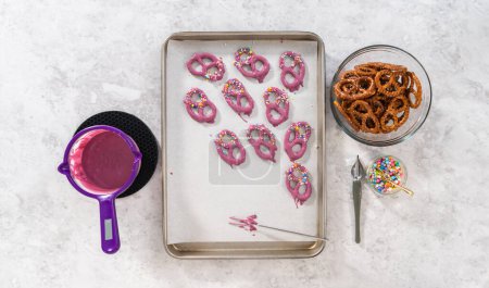 Foto de Flat lay. Dipping pretzels twists into melted chocolate to make mermaid pretzel twists. - Imagen libre de derechos