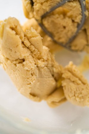 Téléchargez les photos : Mélange d'ingrédients dans un mélangeur électrique de cuisine pour cuire des biscuits sablés en forme de panda avec glaçage au chocolat. - en image libre de droit
